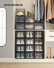 Songmics shoe storage boxes stacked in a wardrobe with shoes and clothing visible