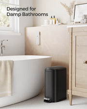 Songmics black pedal bin styled beside a bathtub, designed for damp bathrooms