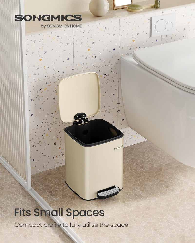Sand beige pedal bin fitted in a small bathroom beside the toilet