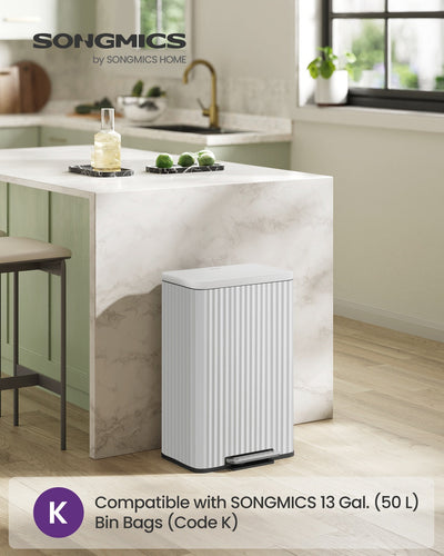 Cloud White pedal bin styled beside a kitchen island with marble worktop