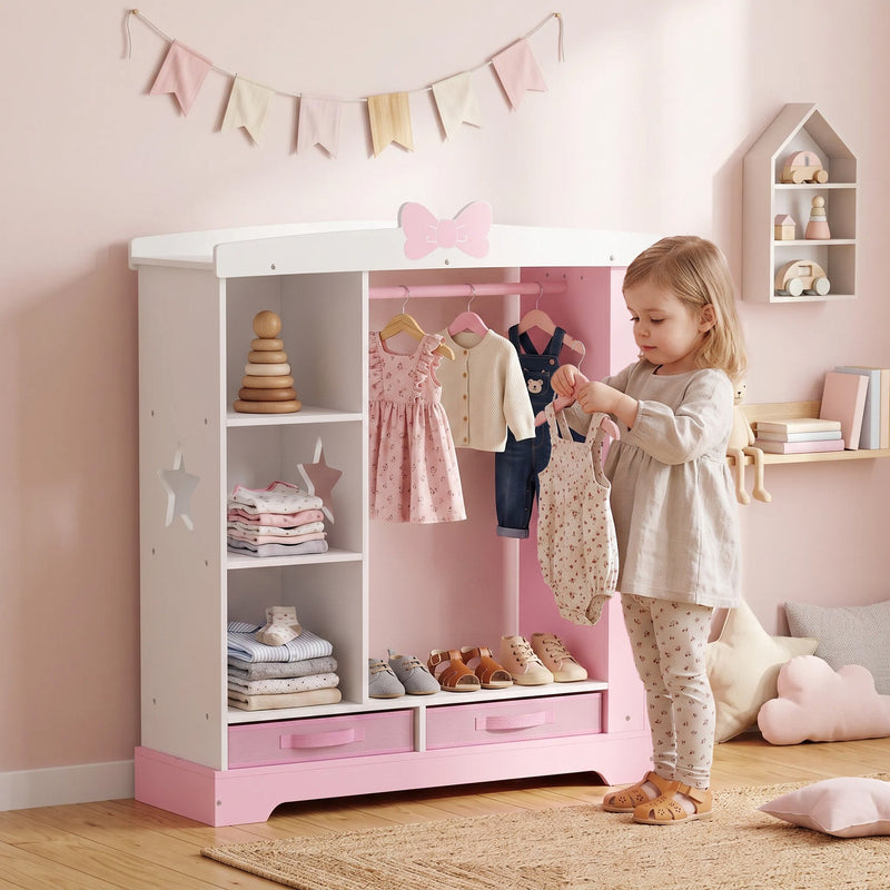 Young girl hanging clothes on the rail inside her pink kids wardrobe