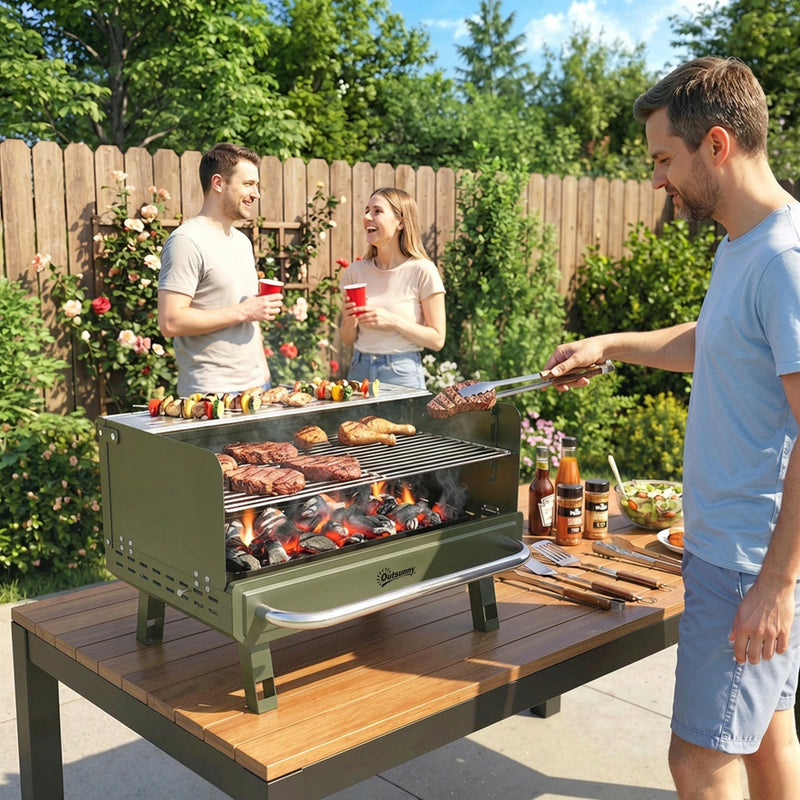 Green Outsunny charcoal BBQ grill in use on a garden table grilling meat and skewers