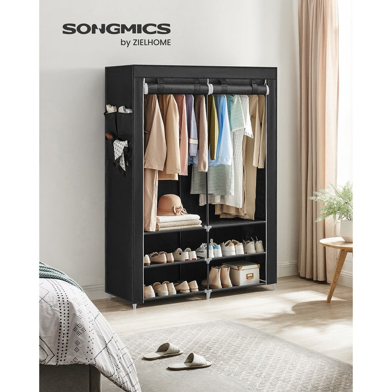 Black portable wardrobe styled in a bedroom next to a bed and a rug