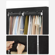 Close-up of the two hanging rails with clothes, plus the cover fastening tab and zip