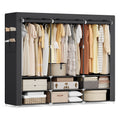 Wide black portable wardrobe filled with clothes and storage boxes on a white background