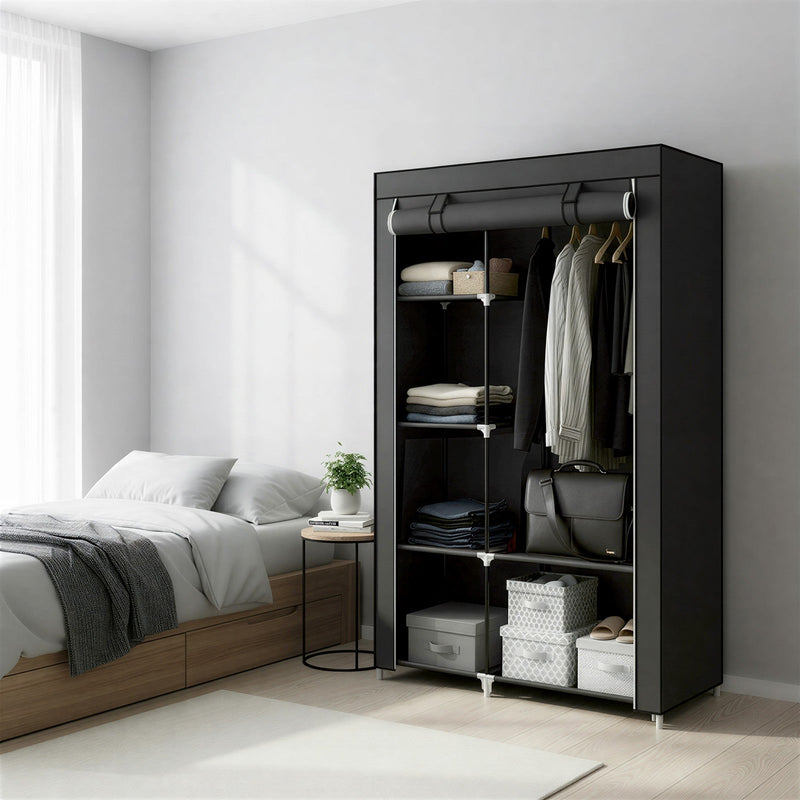 Portable wardrobe open beside a bed, filled with folded clothes, hanging shirts and bags