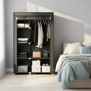 Portable wardrobe styled beside a bed with storage boxes and shoes on the bottom shelf
