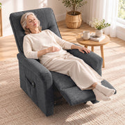 Woman asleep in the dark grey recliner with the footrest raised on a rug