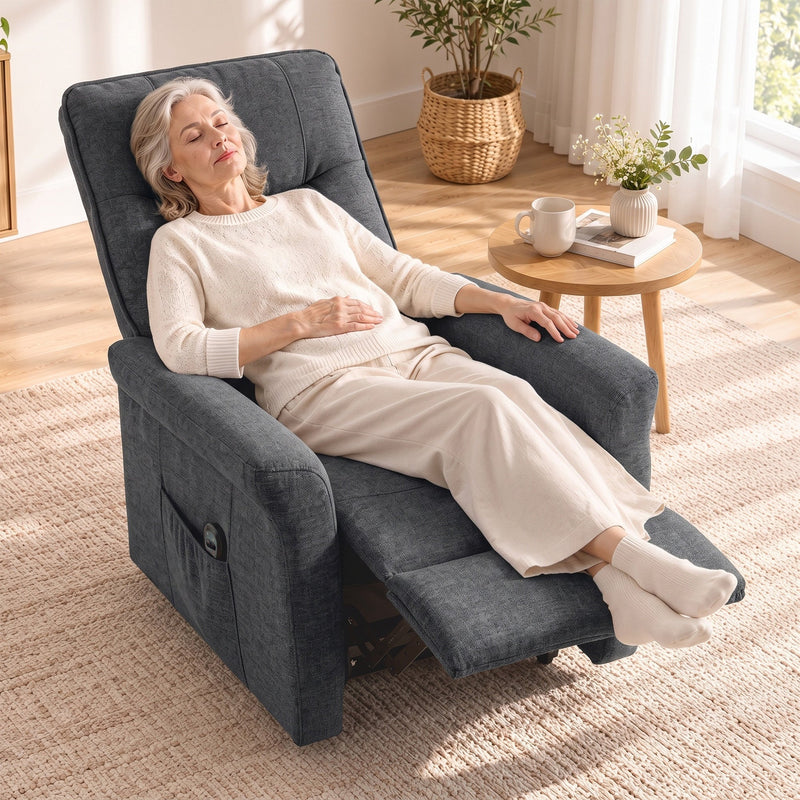 Woman asleep in the dark grey recliner with the footrest raised on a rug