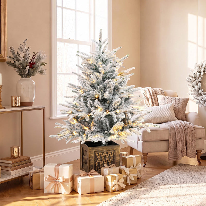 Flocked tree with warm lights on a side table beside a window