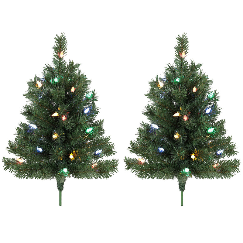 Two green pre-lit outdoor Christmas trees with colourful LEDs and ground stakes on white