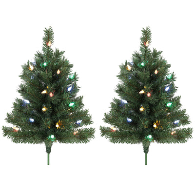 Two green pre-lit outdoor Christmas trees with colourful LEDs and ground stakes on white