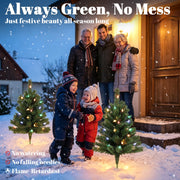 Family beside two lit outdoor trees with no watering, no falling needles and flame-retardant notes