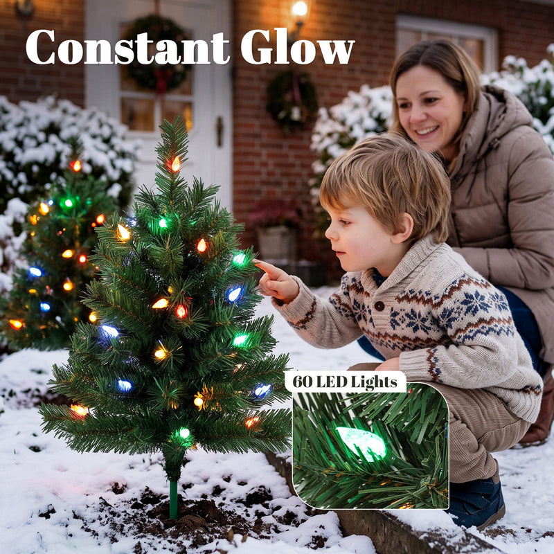 Child pointing at a colourful LED Christmas tree in the snow with 60 LED lights close-up
