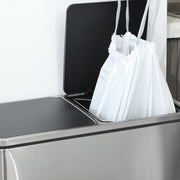 Two white drawstring bin bags fitted inside an open stainless steel double kitchen bin