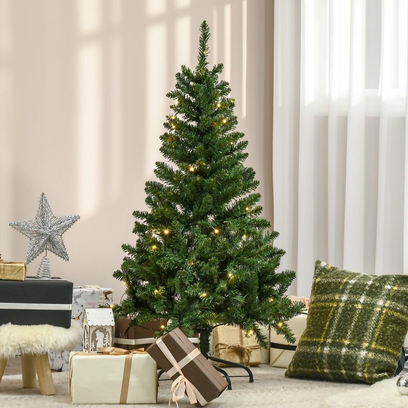 Pre-lit Christmas tree in a bright living room with a star topper and wrapped gifts