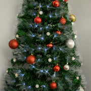 Close-up of red, silver and white baubles on green branches with white fibre optic tips