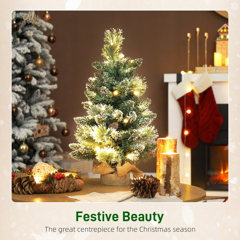 Festive Beauty scene with a glowing mini tree, candles and pine cones on a table