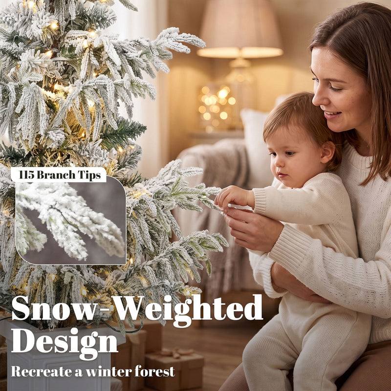 Parent and child by the 3ft snow-weighted flocked tree with a 115 branch tips callout