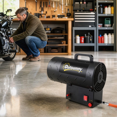 Propane space heater in use on a garage floor next to a motorcycle workbench
