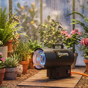 Heater running in a greenhouse surrounded by potted plants