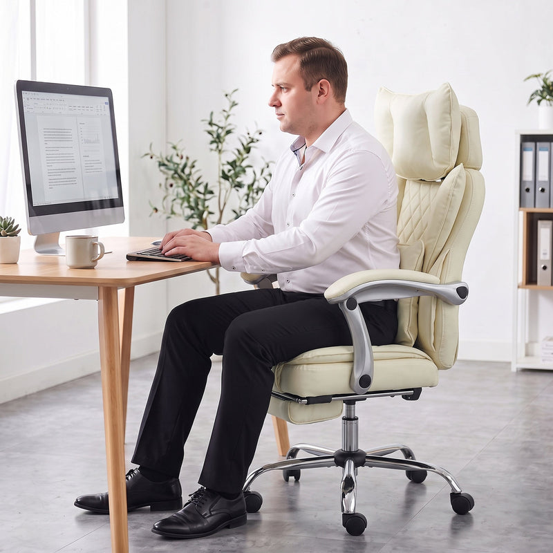 Person typing at a desk while seated upright in the beige office chair
