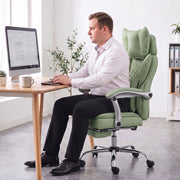 Person typing at a desk while seated upright in the light green office chair