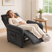 Woman relaxing with feet up in the fully reclined dark grey recliner armchair