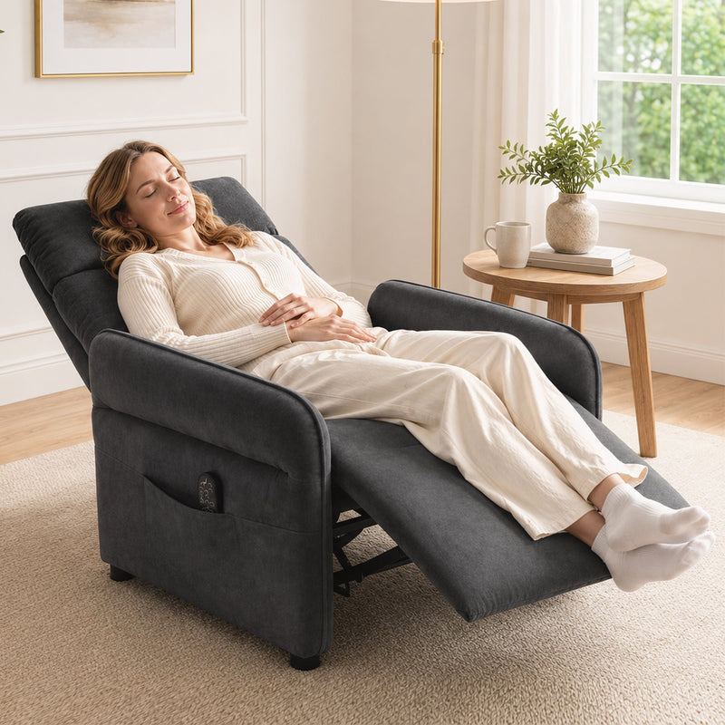 Woman relaxing with feet up in the fully reclined dark grey recliner armchair