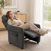 Woman relaxing with a mug of tea in the reclined dark grey armchair by a window