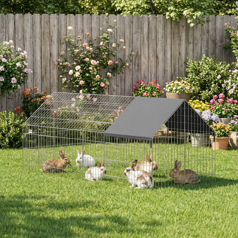 Metal rabbit run with a black shade cover on a garden lawn with rabbits inside
