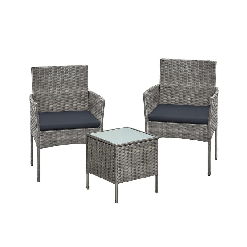 Grey rattan garden set with two cushioned armchairs and a square glass top table on white