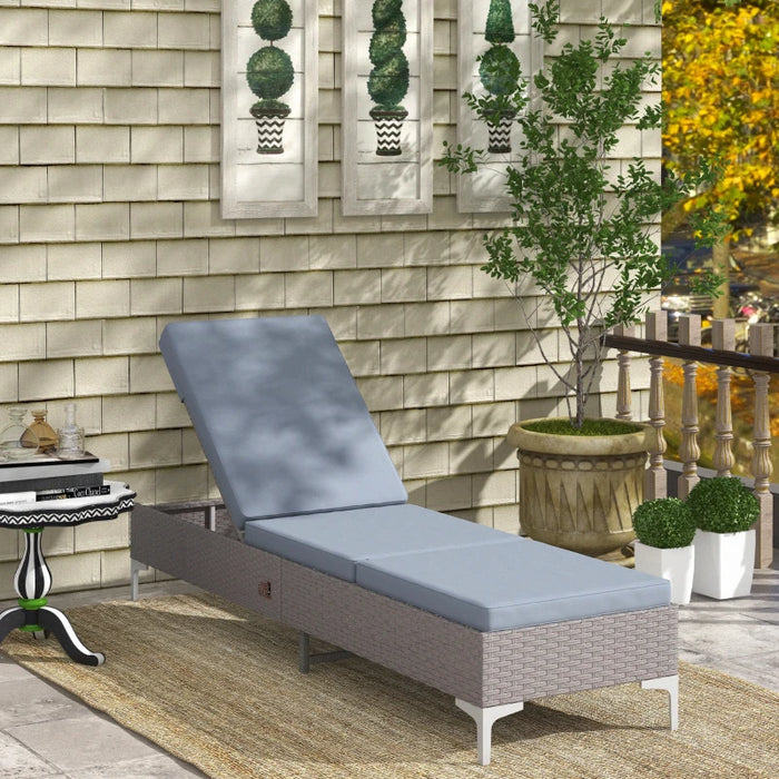 Image of a reclining rattan sun lounger with dark grey cushion 