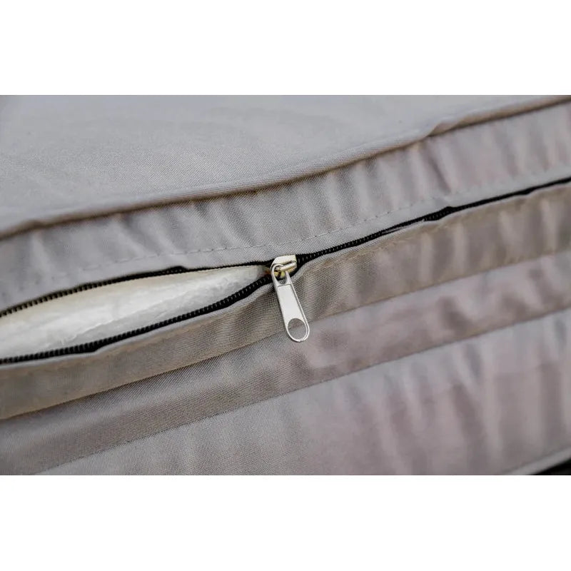 Image of an ergonomic curved rattan sun lounger with cushion and wheels 
