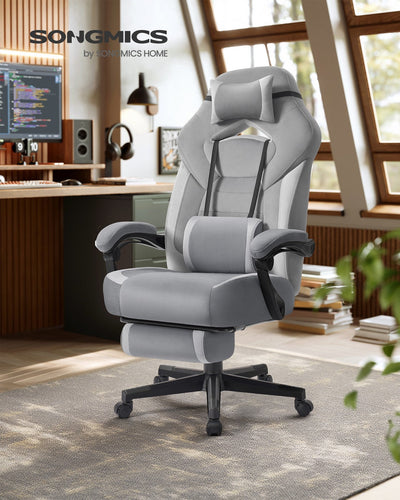 Grey gaming chair with headrest pillow in a home office lifestyle setting