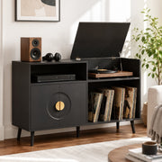Black record player stand in a living room with turntable, speaker and headphones on top