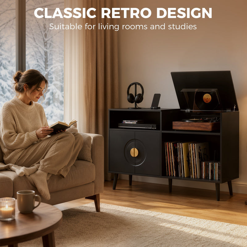 Woman reading in an armchair beside a black record player stand in a living room