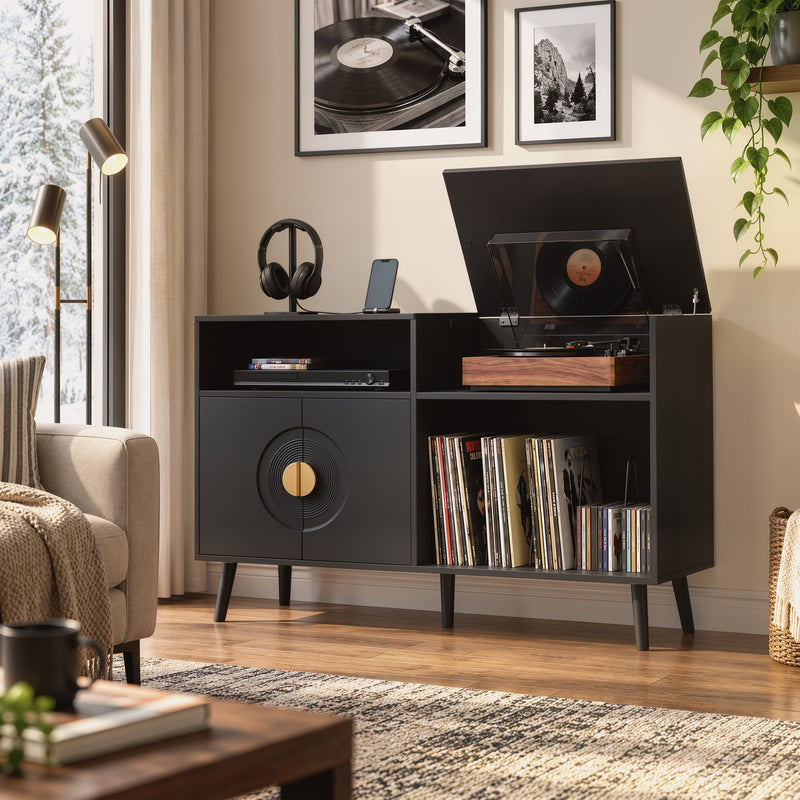 Black record player stand in a living room with framed record artwork on the wall