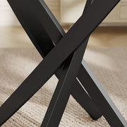 Close-up of black steel cross legs under the glass top