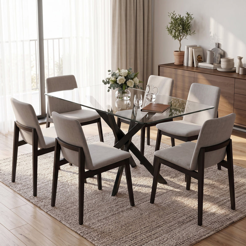 Glass dining table with grey fabric chairs on a rug