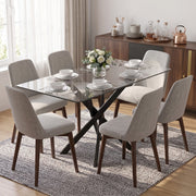 Glass dining table with beige chairs and a vase of flowers