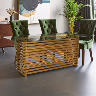 Rectangular glass dining table with matte gold base set for six in a modern dining room