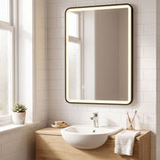 Black LED bathroom mirror mounted vertically above a small basin and wooden cabinet