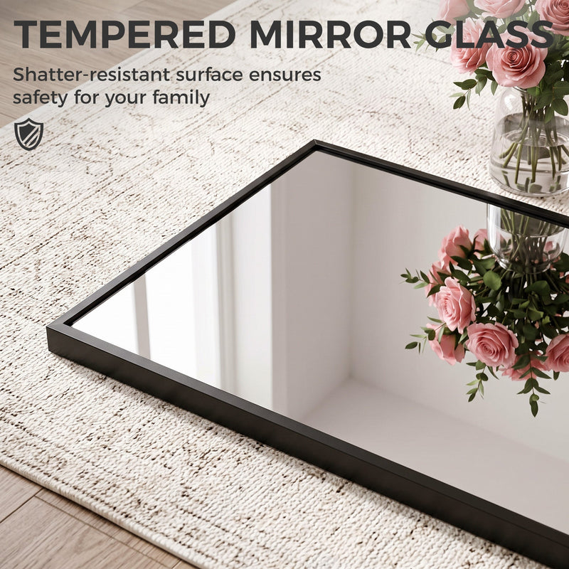 Tempered mirror glass and slim frame lying on a rug beside a vase of roses