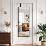 Mirror hanging over a panelled door in a living room with wall lights