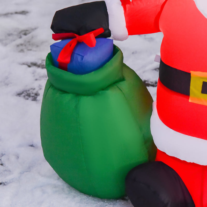 Close-up of the green gift sack with a blue gift on top beside the Santa