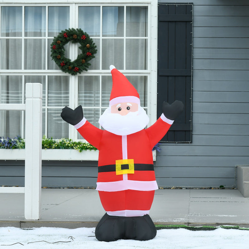 Inflatable Santa with open arms in front of a grey house with a wreath and snowy ground
