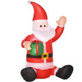 Sitting inflatable Santa waving and holding a green gift box, white studio shot