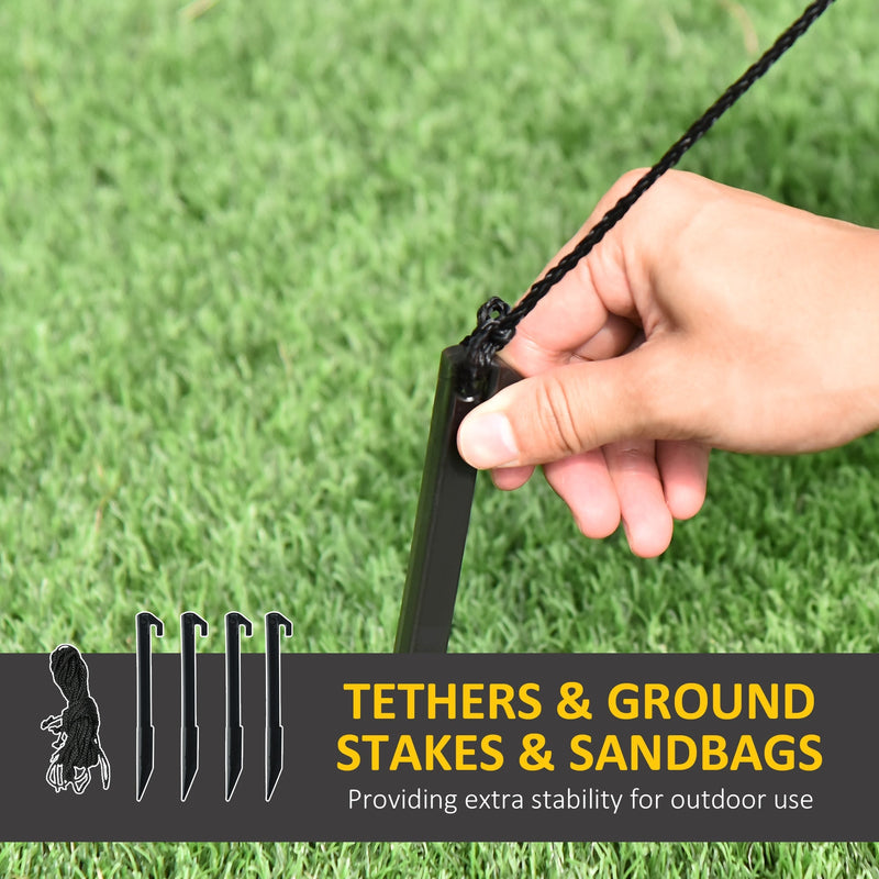 Hand pushing a ground stake with tether into grass beside four stakes