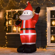 Inflatable Santa lit up at night outside a brick house with a wreathed front door